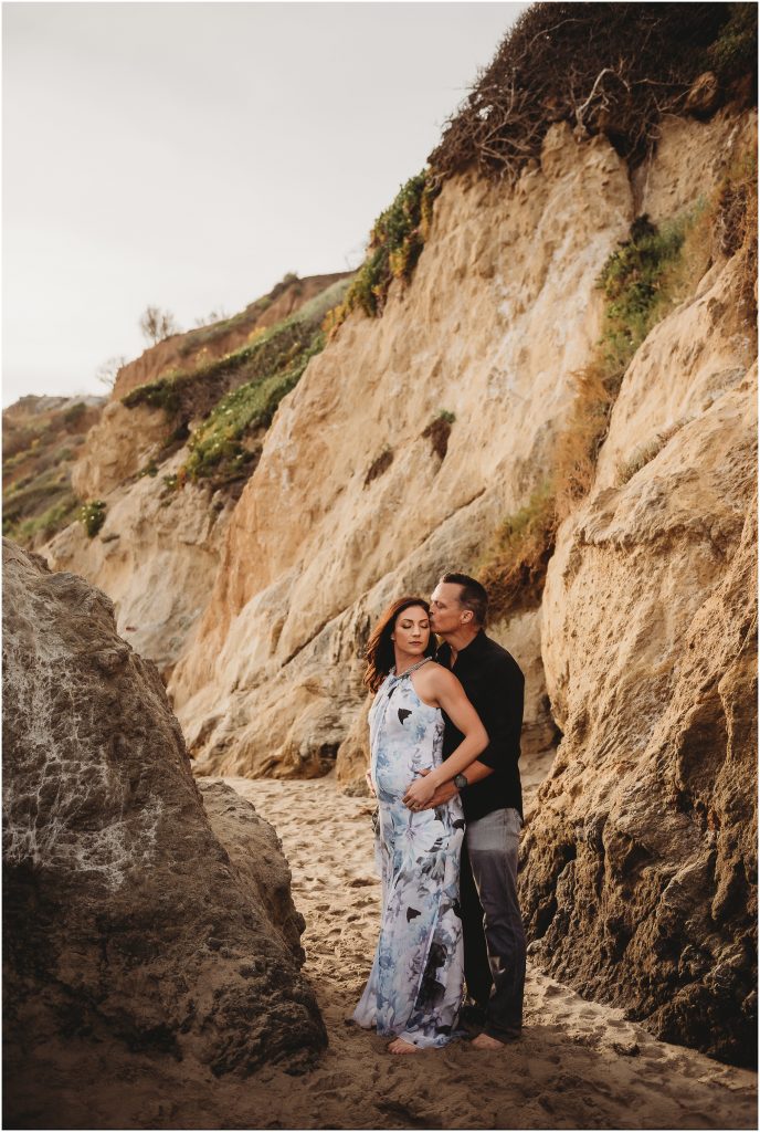 Couple during maternity photos at El Matador Beach in Malibu, CA during sunset