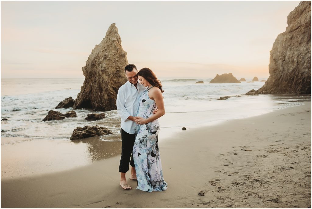 Couple during maternity photos at El Matador Beach in Malibu, CA during sunset