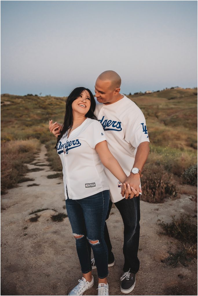Couple at sunset at Sycamore Canyon Wilderness Park in Riverside, CA wearing dodger jerseys for engagement photos