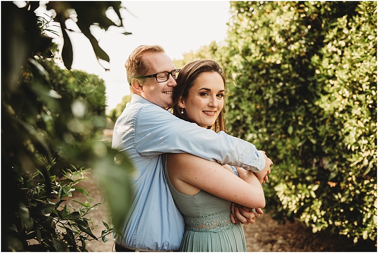 couple in orange groves at California Citrus State Historic Park in Riverside, CA by Dallas Wedding Photographer for their engagement session 