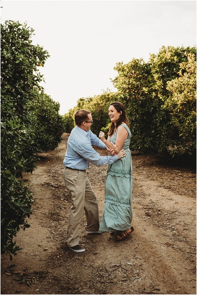 couple playing in orange groves at California Citrus State Historic Park in Riverside, CA by Dallas Wedding Photographer for their engagement session 