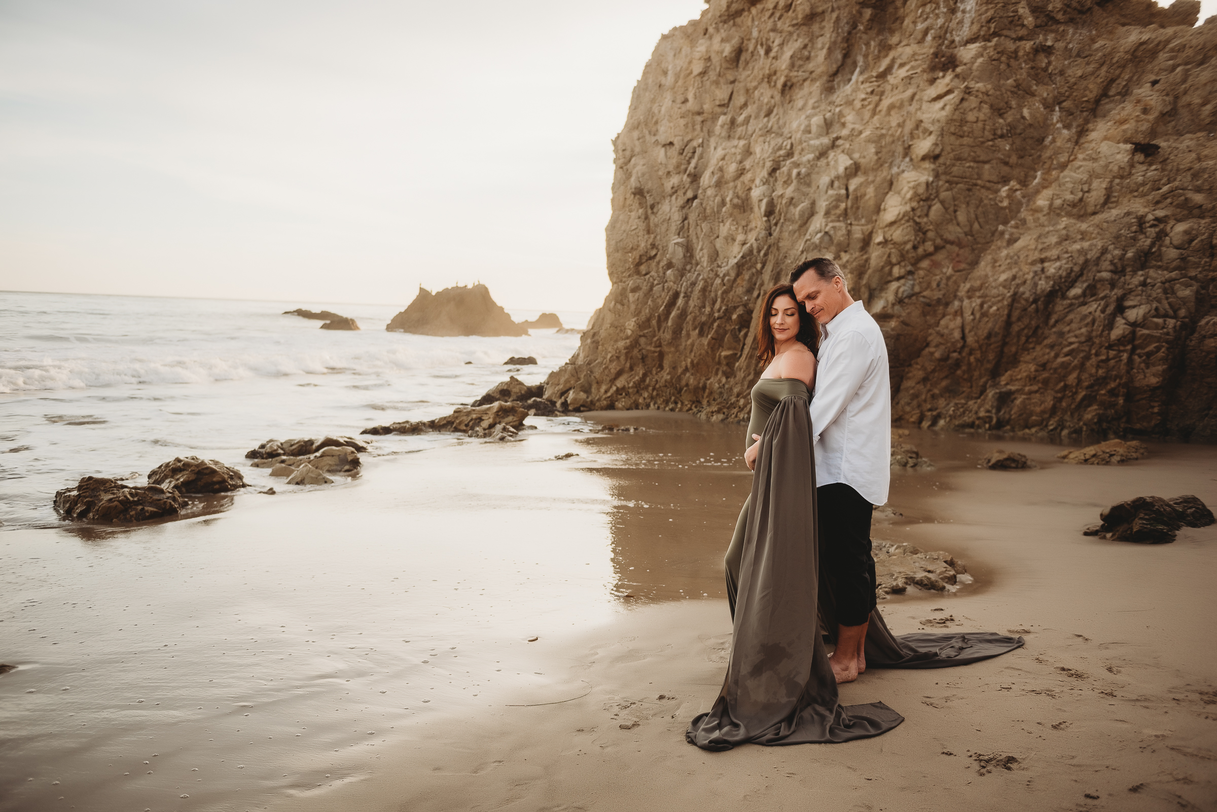 Couple during maternity photos at El Matador State Beach in Malibu